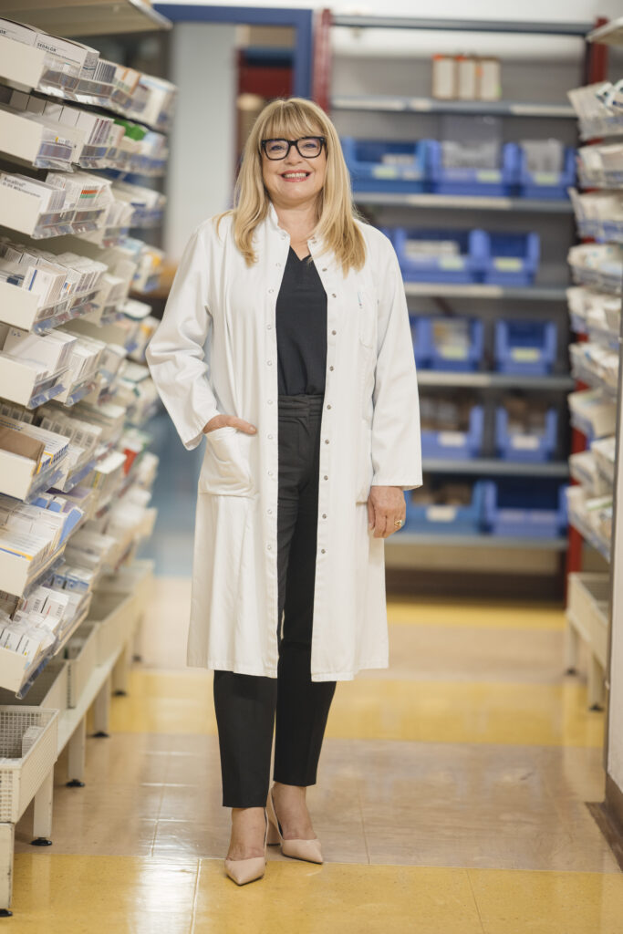 Martina Jeske, Leiterin der Anstaltsapotheke an den tirol kliniken, steht im Arzneimittellager und erklärt, wie die Apotheke die Arzneimittelversorgung im Krankenhaus sicher stellt.